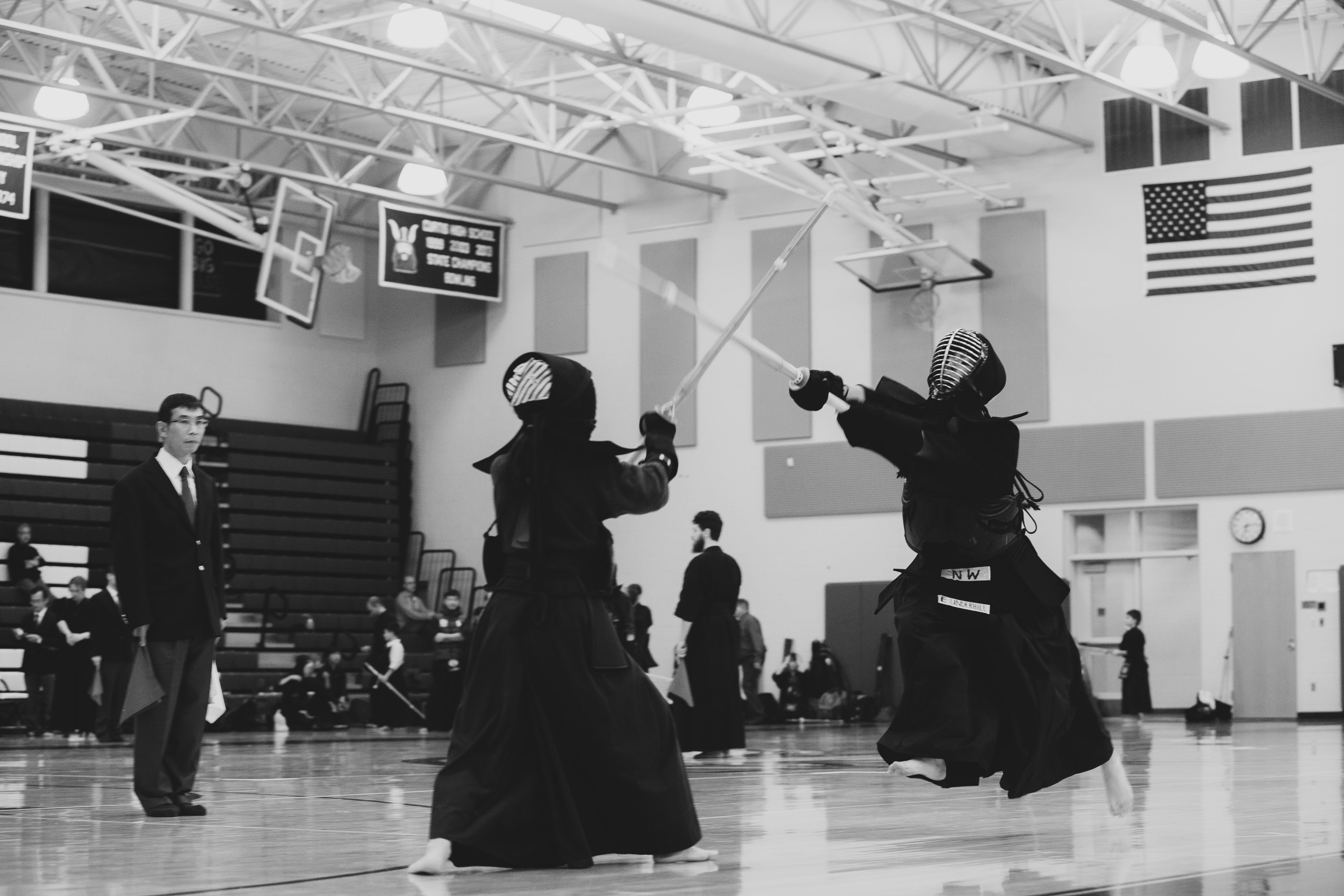 Kendo match in progress with a judge observing from the side